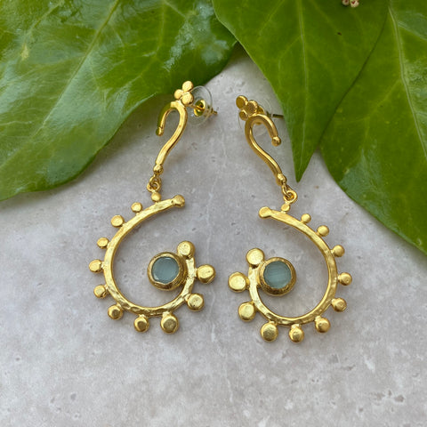 gold swirl earrings surrounded by gold circles and aqua stone